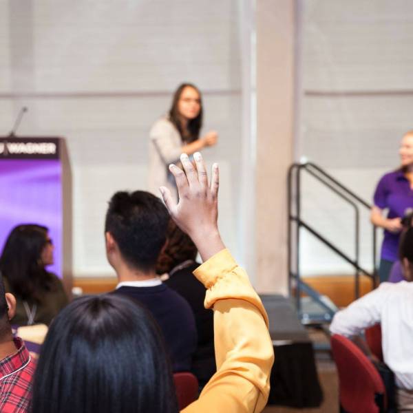 Online MHA student raising their hand at an immersion